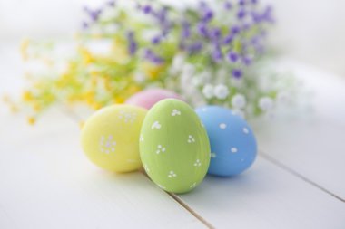 Colorful decorated easter eggs on white wood background.  clipart