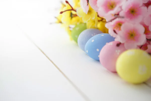 Huevos de Pascua sobre fondo de madera blanca vista superior inusual . — Foto de Stock