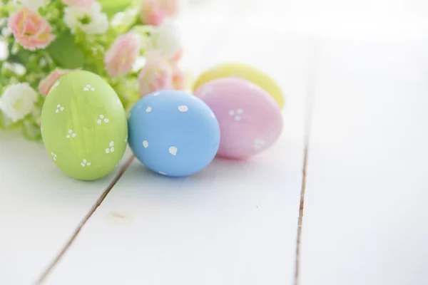 Coloridos huevos de Pascua decorados sobre fondo de madera blanca . — Foto de Stock