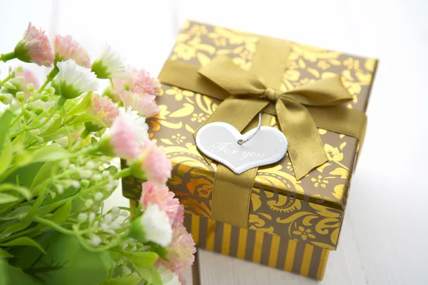 Confezione regalo con cuore sul tavolo in legno per San Valentino — Foto Stock