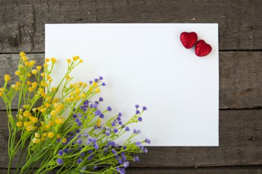 Çiçek ve kalp şekli bir not kağıdına ahşap arka plan.