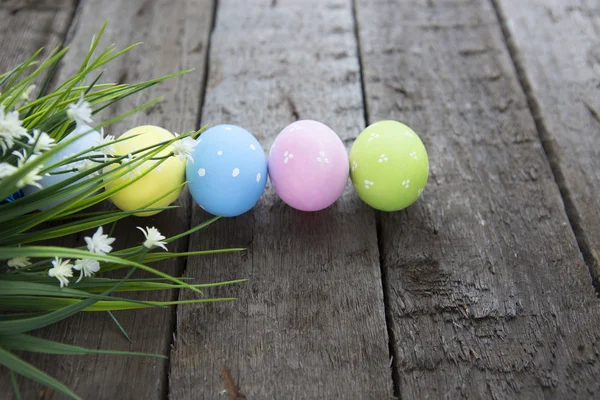 Paaseieren met bloemen op houten achtergrond — Stockfoto