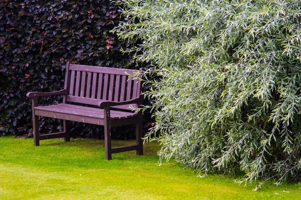 Banco de jardín marrón con hierba verde —  Fotos de Stock