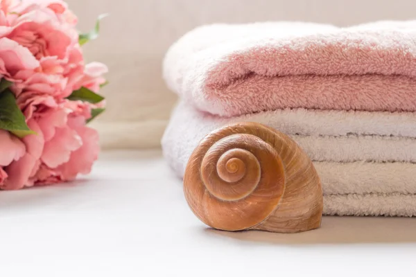 Toallas plegadas en el mostrador del baño con flores — Foto de Stock