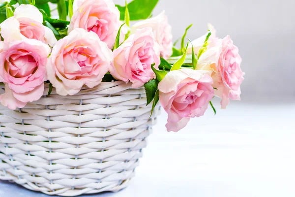 Beautiful, pink roses in a white basket close up — Stock Photo, Image