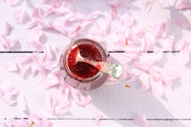 Taze frambuaz reçeli ışık rustik masa romantik kahvaltı arka plan, kiraz çiçeklerle kaplı bir kavanoz yakın çekim, bahçede