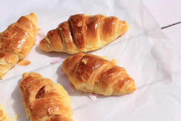 Verse croissants op oude houten achtergrond, plat — Stockfoto