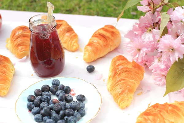 Fresh French croissants on old wooden background, romantic breakfast in the garden — Stock Photo, Image