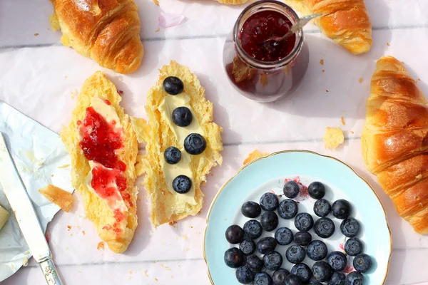 Färska franska croissanter på gamla trä bakgrund, romantisk frukost i trädgården — Stockfoto