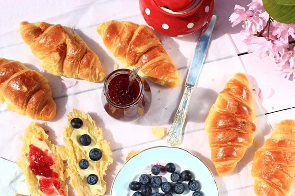 Färska franska croissanter på gamla trä bakgrund, romantisk frukost i trädgården — Stockfoto