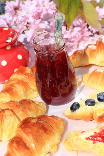 Färska franska croissanter på gamla trä bakgrund, romantisk frukost i trädgården — Stockfoto