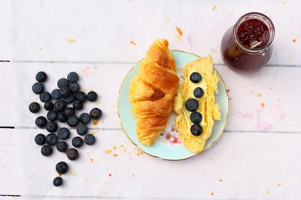 Frisse Franse croissants op oude houten achtergrond, romantische ontbijt in de tuin — Stockfoto