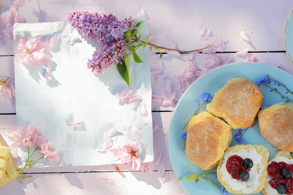 Hermoso, fondo de desayuno de primavera con bollos escoceses, flores de color lila y cereza —  Fotos de Stock