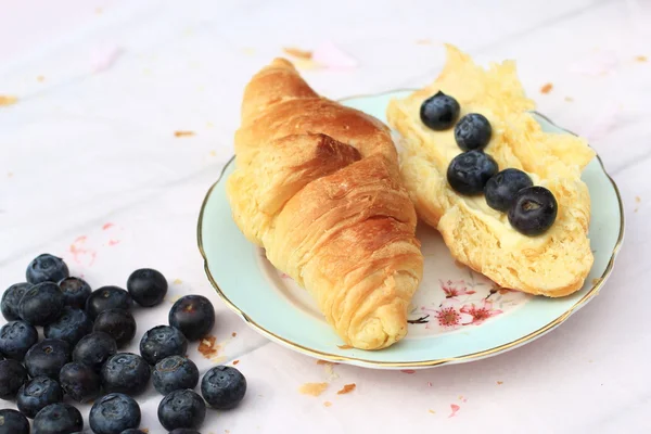 Croissants franceses frescos sobre fondo de madera viejo, desayuno romántico en el jardín —  Fotos de Stock