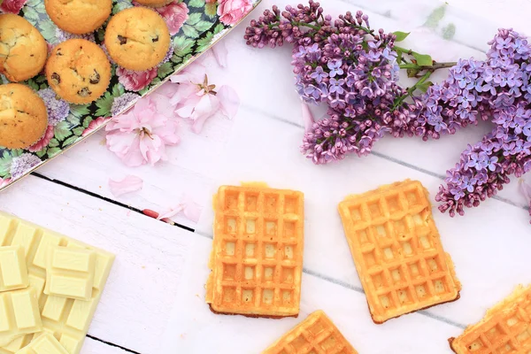 Waffles de bélgica recém-assados em mesa de madeira romântica com flores lilás — Fotografia de Stock