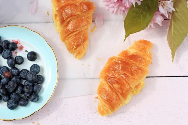 Delicioso café da manhã com croissants frescos e bagas maduras no fundo de madeira velho, foco seletivo — Fotografia de Stock