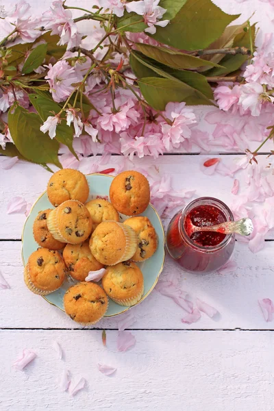 Delicioso escocés, magdalenas en una mesa rosa de madera, desayuno fresco en el jardín de primavera —  Fotos de Stock