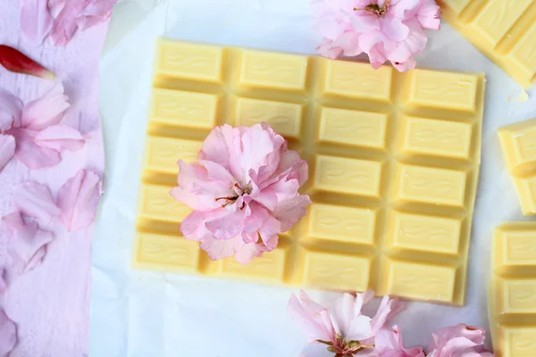 Une barre de chocolat blanc avec des fleurs de cerisier japonais — Photo