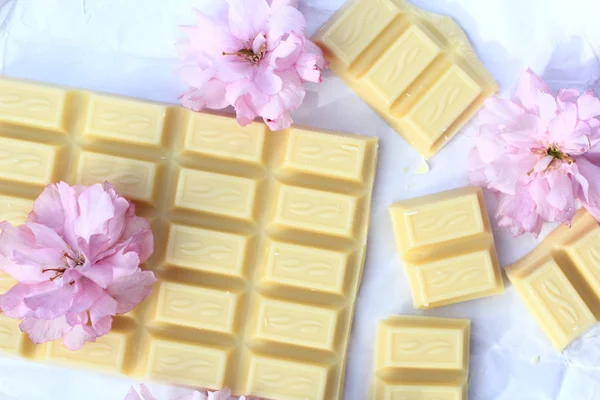 Uma barra de chocolate branco com flores de cerejeira japonesas — Fotografia de Stock