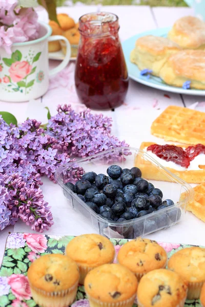 Vacker blommig bakgrund med vårblommor och en låda med blåbär — Stockfoto