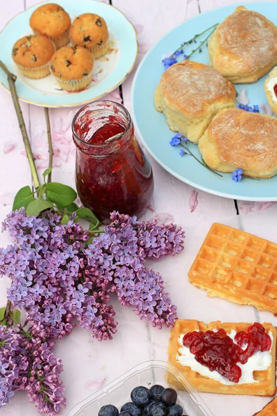 Vacker blommig bakgrund med vårblommor och en låda med blåbär — Stockfoto