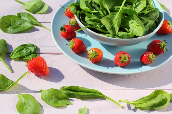 Insalata di spinaci freschi con spinaci e fragole su tavolo rosa chiaro in legno — Foto Stock