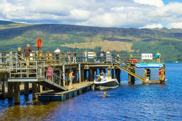 Люди, веселящиеся в солнечный день в Luss Pier, Ломонд, Ардженто и Озил, Шотландия, 21 июля 2016 года — стоковое фото