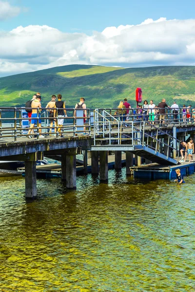 Люди, веселящиеся в солнечный день в Luss Pier, Ломонд, Ардженто и Озил, Шотландия, 21 июля 2016 года — стоковое фото