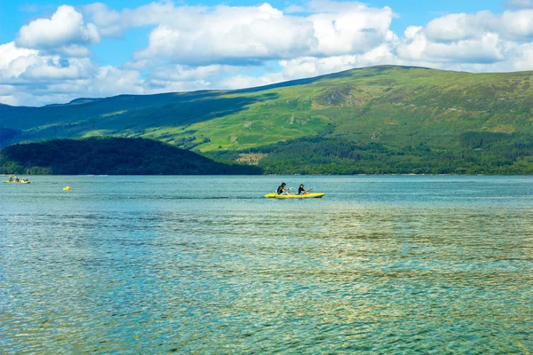 Toeristen op kano op kalme blauwe Loch Lomond meer in Luss, Schotland, 21 juli, 2016 — Stockfoto