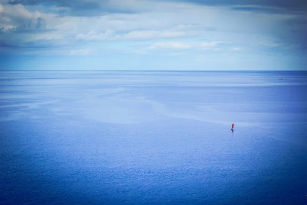 Una piccola barca su un oceano enorme — Foto Stock