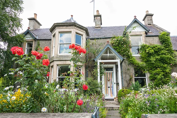 Ancienne maison britannique avec fenêtre et roses grimpantes — Photo