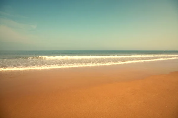 Piękna plaża z piaskiem, Błękitne fale i niebo — Zdjęcie stockowe