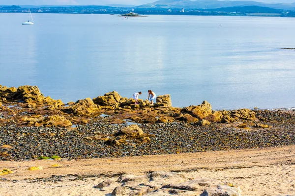 Děti, černé písky, Aberdour, Skotsko. — Stock fotografie