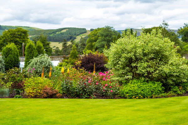 Beautiful walled, victorian garden with variety of blooming flowers and trees