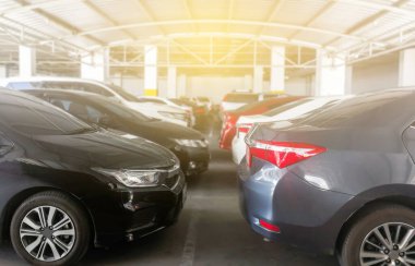 Alışveriş merkezinin arka tarafındaki kapalı otoparkta arabaları park ediyor.