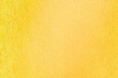 Altın duvar dokusu arka plan. Duvarda parlak parlak sarı folyo boya ve ışık yansıması.,