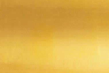 Altın duvar dokusu arka plan. Duvarın yüzeyinde parlak parlak sarı folyo boya, parlak yansımalı, parlak altın renkli duvar kağıdı.