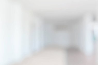 Modern beyaz ofis binasının boş beyaz koridor koridoru. Giriş kapısı bulanık.