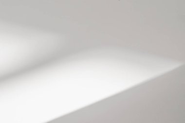 Beyaz duvar arkaplanındaki pencerenin soyut ışık yansıması ve gri gölgesi, arkaplan ve modelleme isteği için koyu gri ve güneş ışığının köşegen geometrik örtüsü