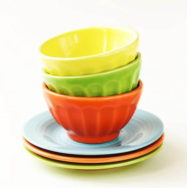 Cuencos y platos de colores sobre un fondo blanco — Foto de Stock