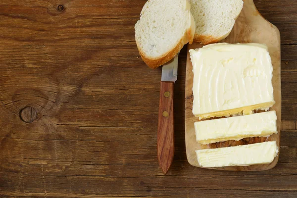 Bloque de mantequilla orgánica fresca en una tabla de madera — Foto de Stock