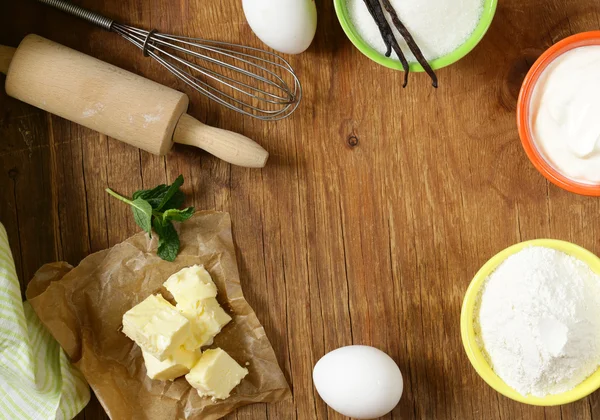 Ingredients for pastry - butter, milk, eggs, flour and vanilla sugar on a wooden background — Stock Photo, Image