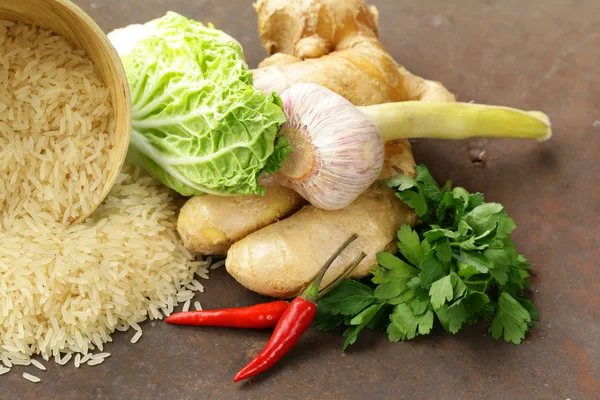Asijské potraviny - rýže, zázvor, chilli papričkou na kamenné pozadí — Stock fotografie