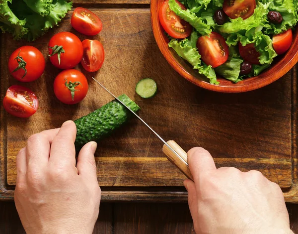 Groente salade (sla, tomaten, komkommers) koken op een houten plank, bovenaanzicht — Stockfoto