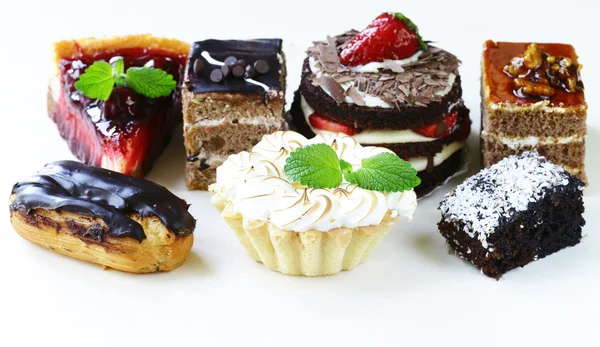 Sobremesas, bolos e bolos variados sobre um fundo branco — Fotografia de Stock