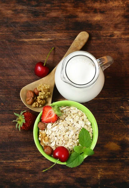 Harina de avena, leche, bayas y frutos secos para una alimentación saludable —  Fotos de Stock