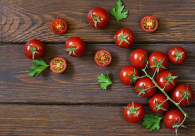 Bütün küçük kiraz domates ve maydanoz yaprakları ile yarıya indirir 