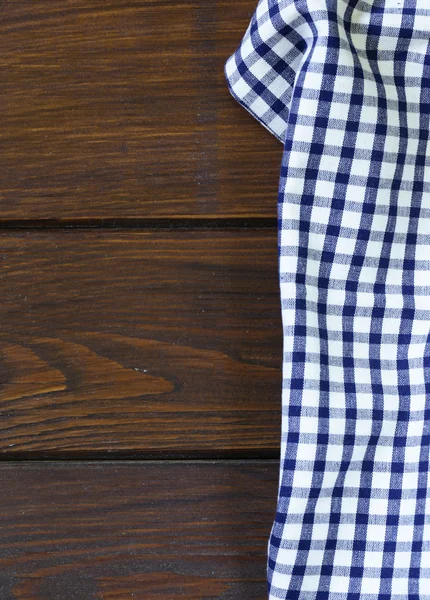 Dřevěná domácí pozadí s kostkovanou utěrku, ubrousek — Stock fotografie