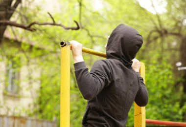 yatay çubuğu'nda, açık havada egzersiz adam çekti