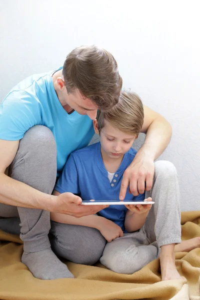 Ojciec i syn, grając na elektroniczny tablet — Zdjęcie stockowe